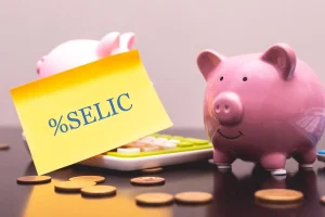 Cofrinho com moedas e papel escrito Selic representando taxa de juros e investimentos