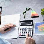 Pessoa usando calculadora para analisar financiamento de imóvel com gráfico de eficiência energética