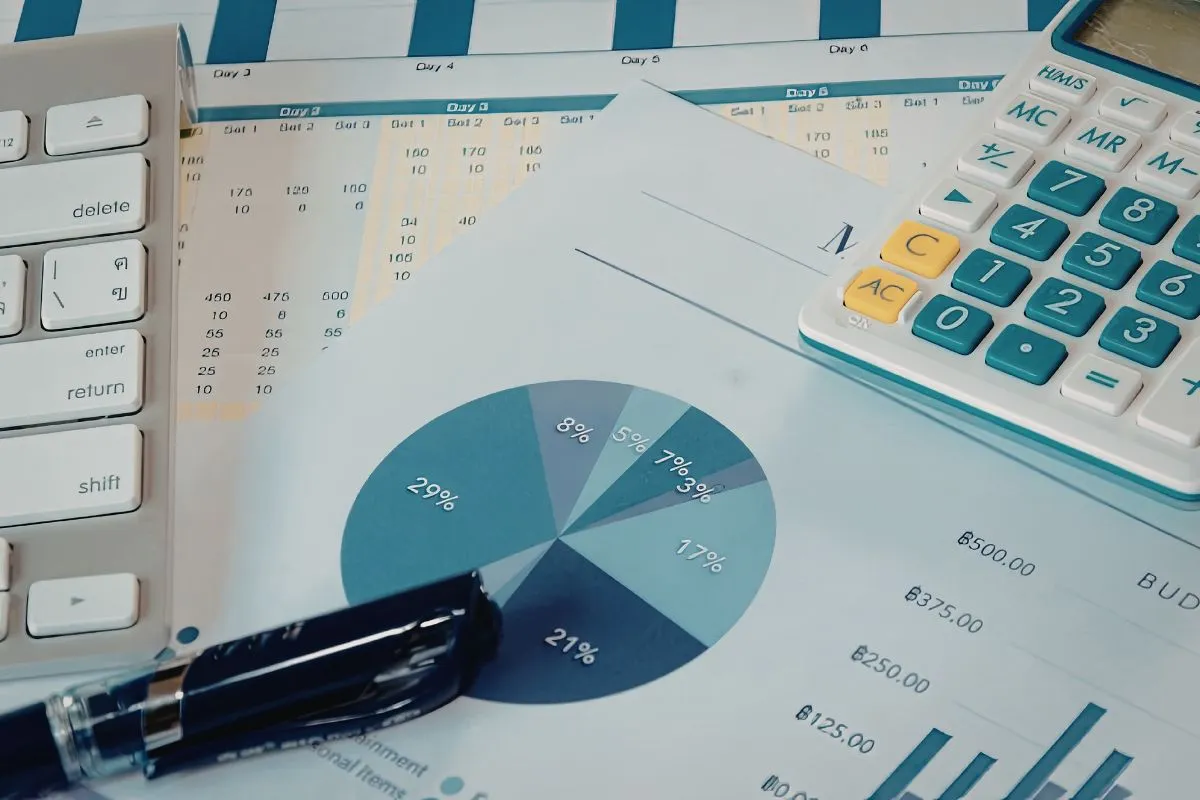 Relatórios financeiros com gráficos, calculadora e caneta sobre mesa de trabalho