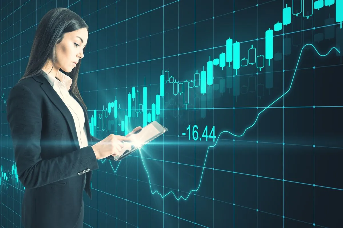 Mulher analisando gráficos financeiros em tablet com indicadores de crescimento no mercado