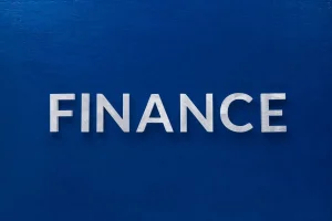 Palavra finance em letras sobre fundo azul representando finanças e economia