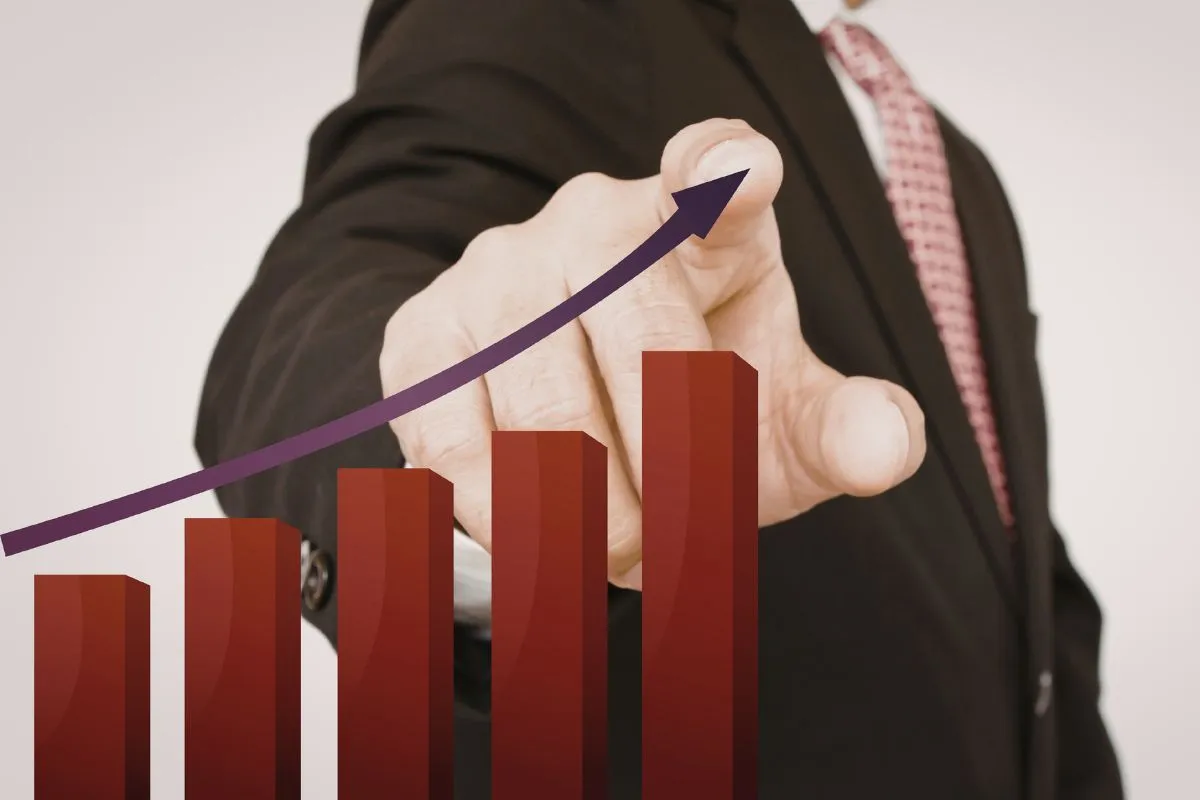 Executivo apontando gráfico financeiro de alta associado ao crescimento econômico e valorização de investimentos