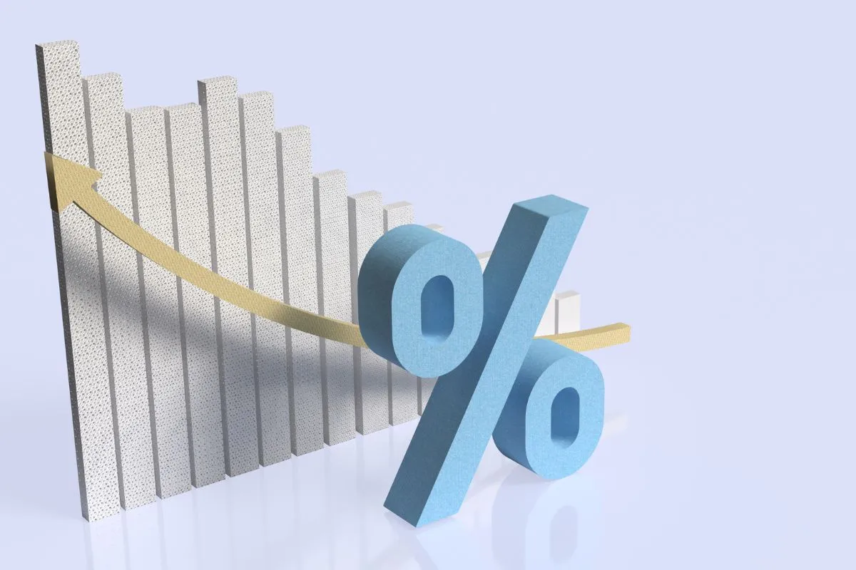 Símbolo de porcentagem com seta descendente indicando queda nas taxas de juros e retração econômica