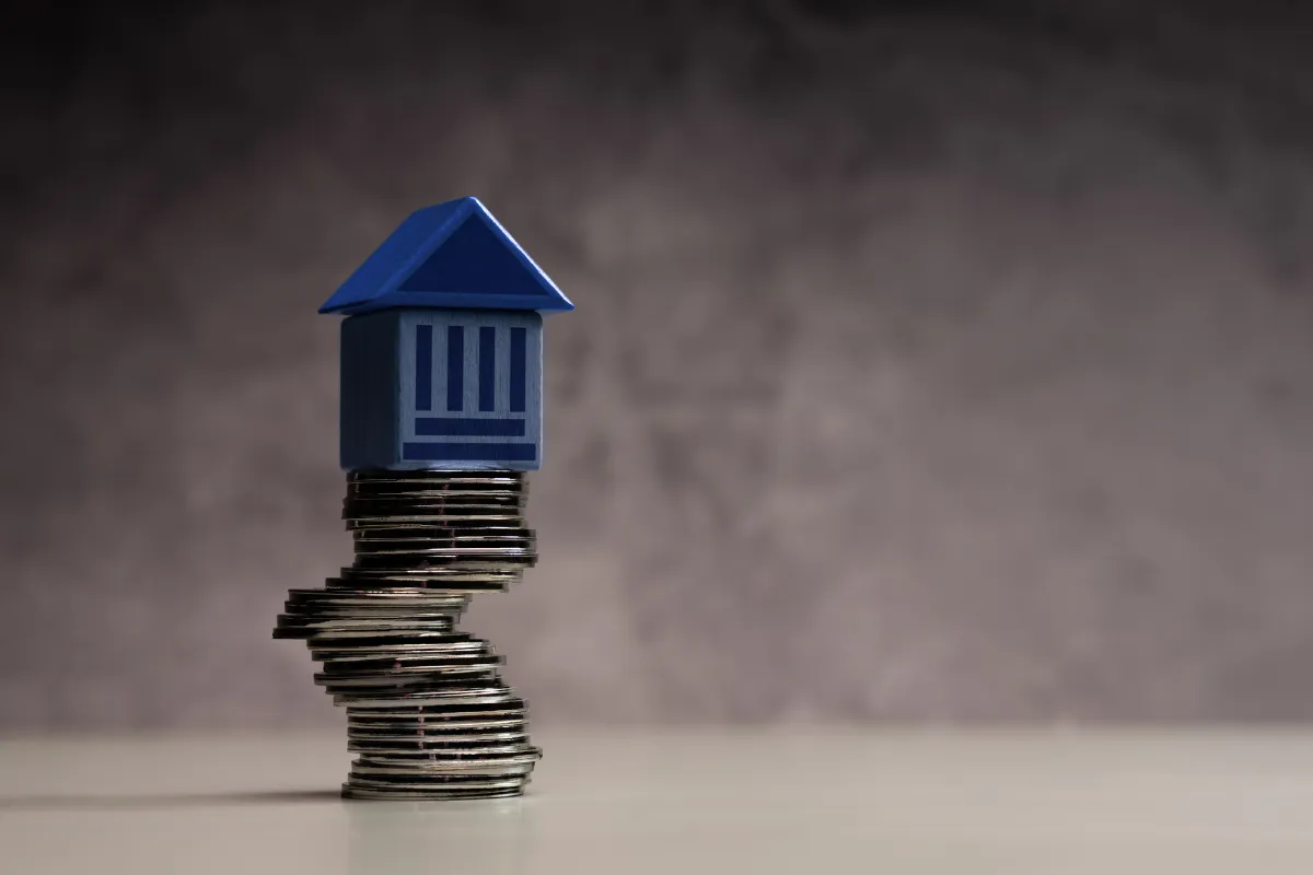 Miniatura de prédio sobre pilha de moedas simbolizando privilégios tributários e impacto no gasto público