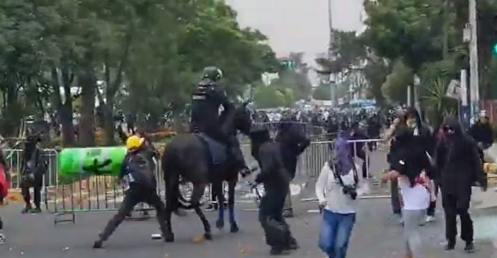Momento em que manifestante atira baliza sobre um policial | Foto: Reprodução/X
