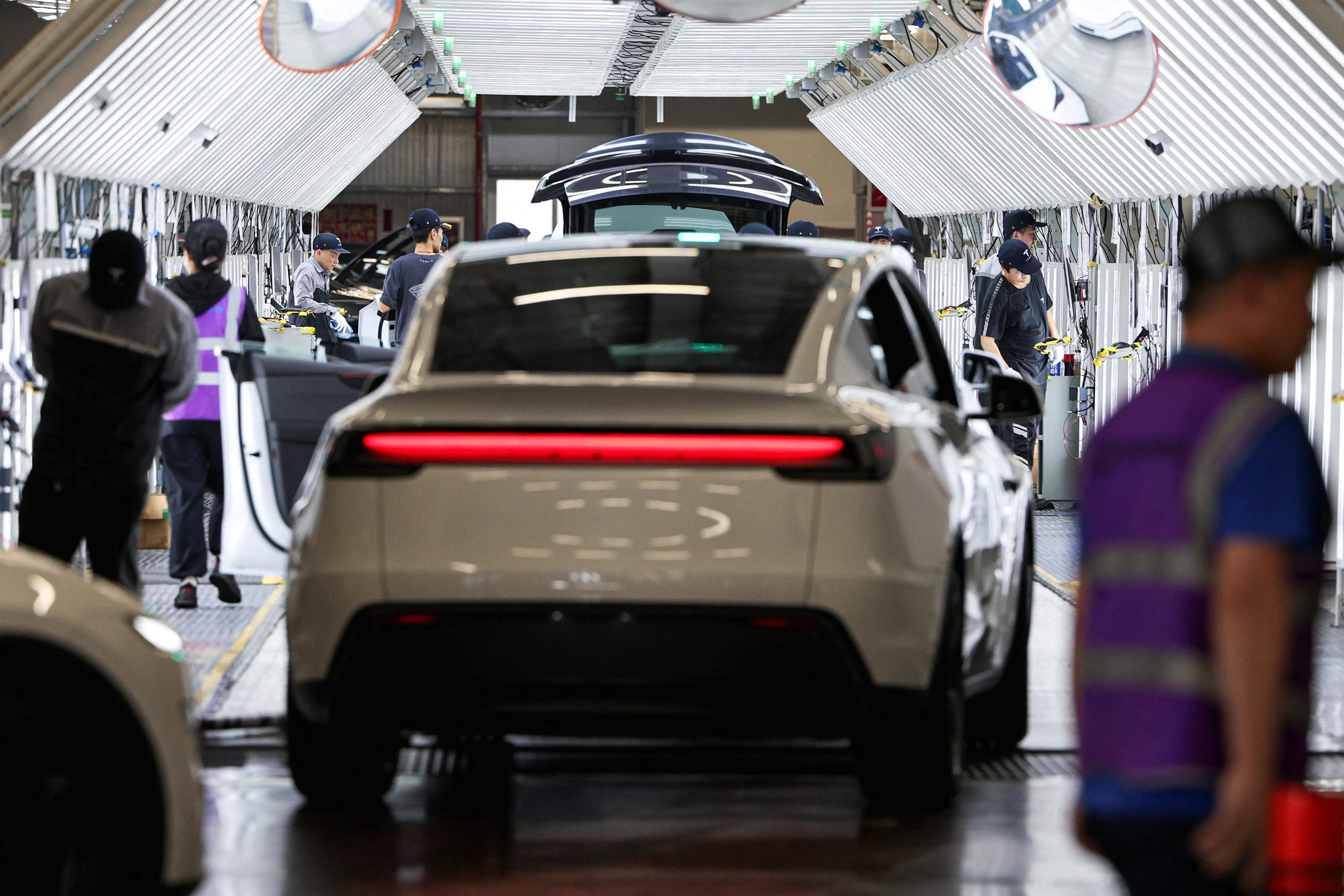 Funcionários trabalham na Tesla Gigafactory durante uma viagem de mídia organizada pelo governo em Xangai, China - 14/4/2026 | Foto: Go Nakamura/Reuters