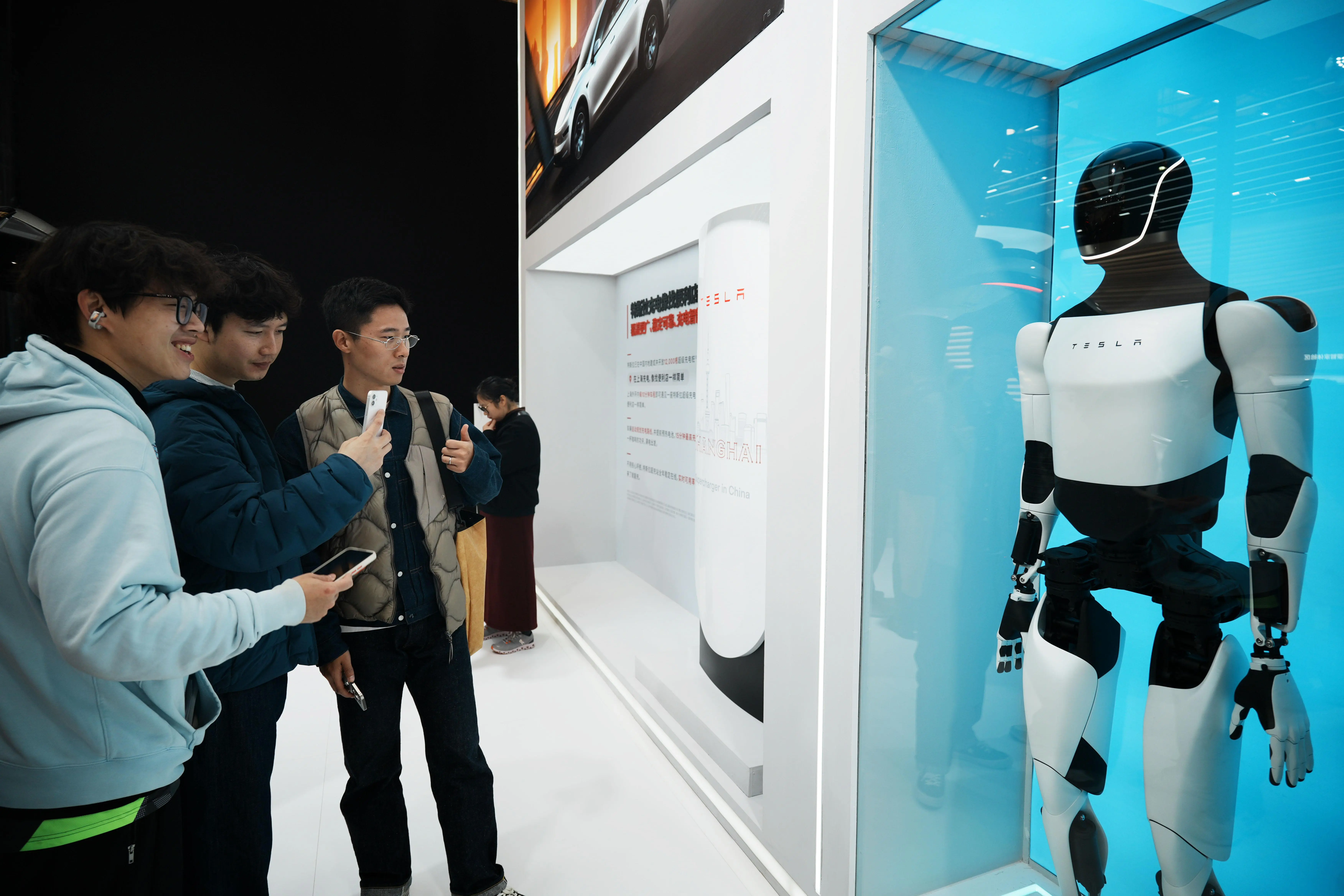 Um cliente vê o robô Optimus em uma loja Tesla em Hangzhou, província de Zhejiang, no leste da China - 21/4/2026 | Foto: Go Nakamura/Reuters