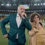 Na imagem, Belo e Alcione cantam o Hino Nacional antes do amistoso da seleção / Foto: Reprodução/SporTV