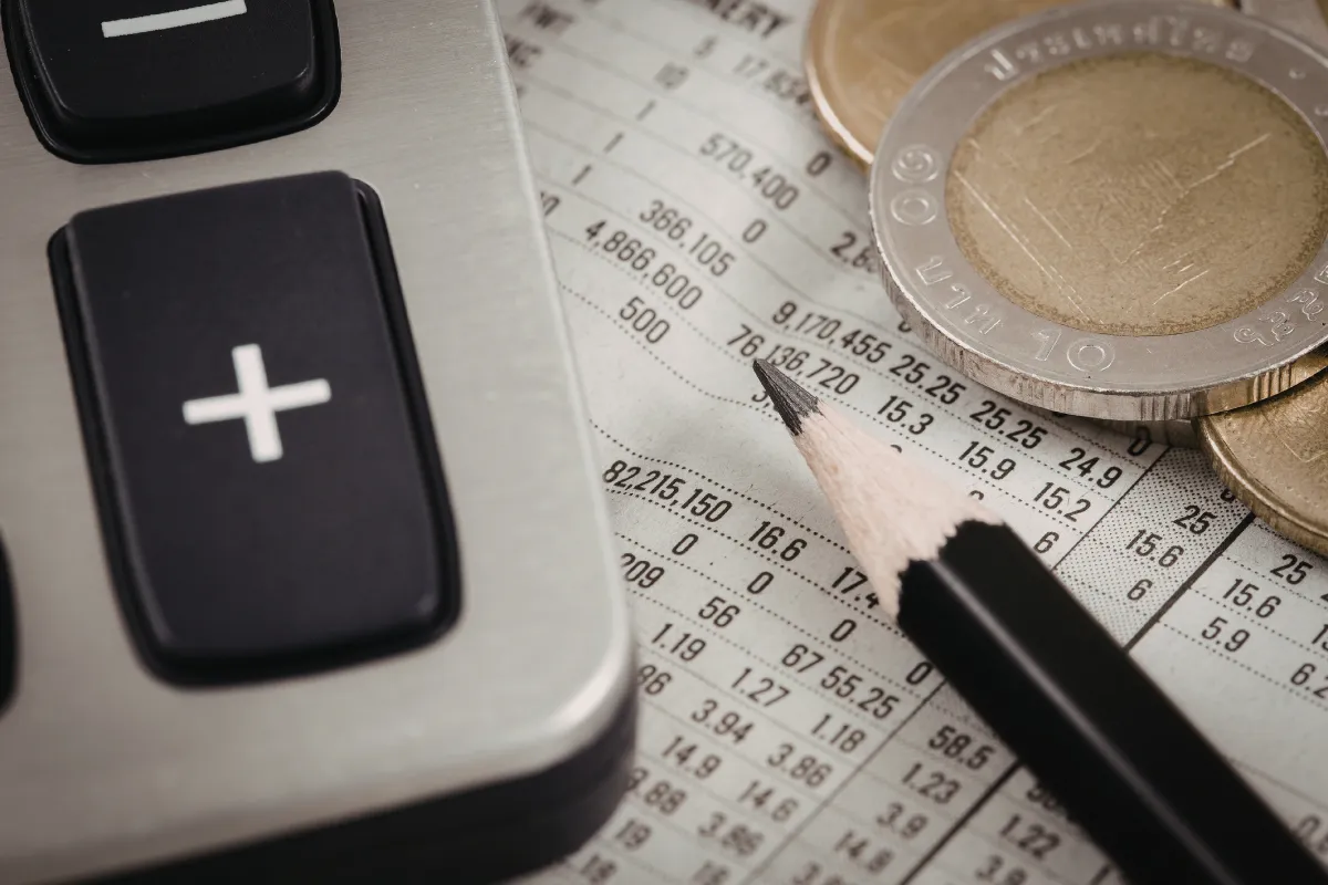 Calculadora, moedas e planilha financeira ilustram o planejamento necessário para contratar crédito rural com segurança.