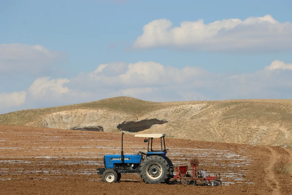 Trator realizando preparo do solo em área agrícola aberta dentro das atividades do agronegócio.
