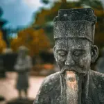 Confúcio rodeado por livros e símbolos de sabedoria, refletindo sobre a vida simples
